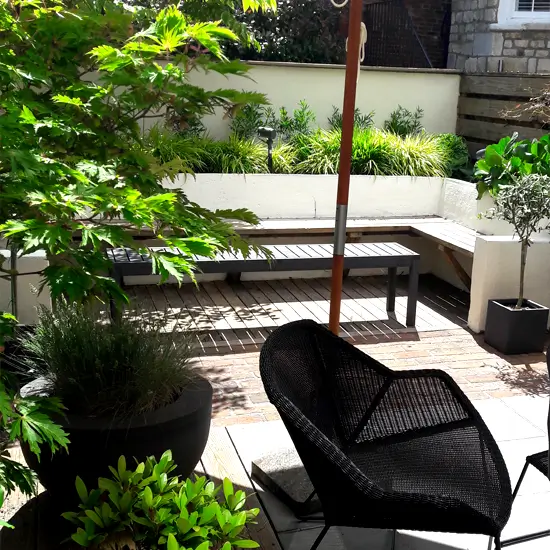 courtyard garden in York with shade and seating, rendered walls retaining plants